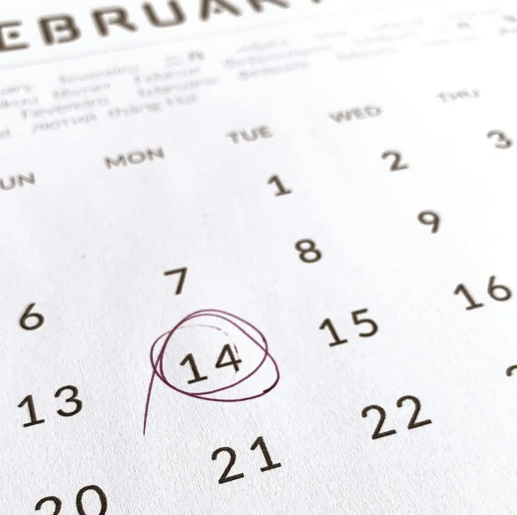 a close up of a calendar with a red marker