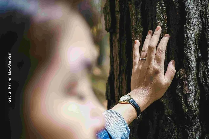 femme qui touche un arbre en fermant les yeux