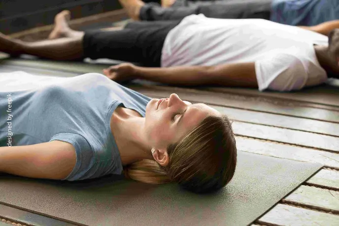 personnes allongées sur des tapis en relaxation  en cours collectif