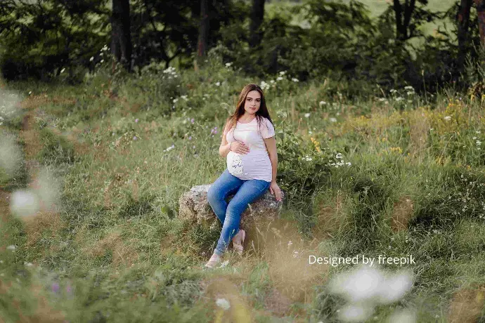 femme enceinte assise dans la nature